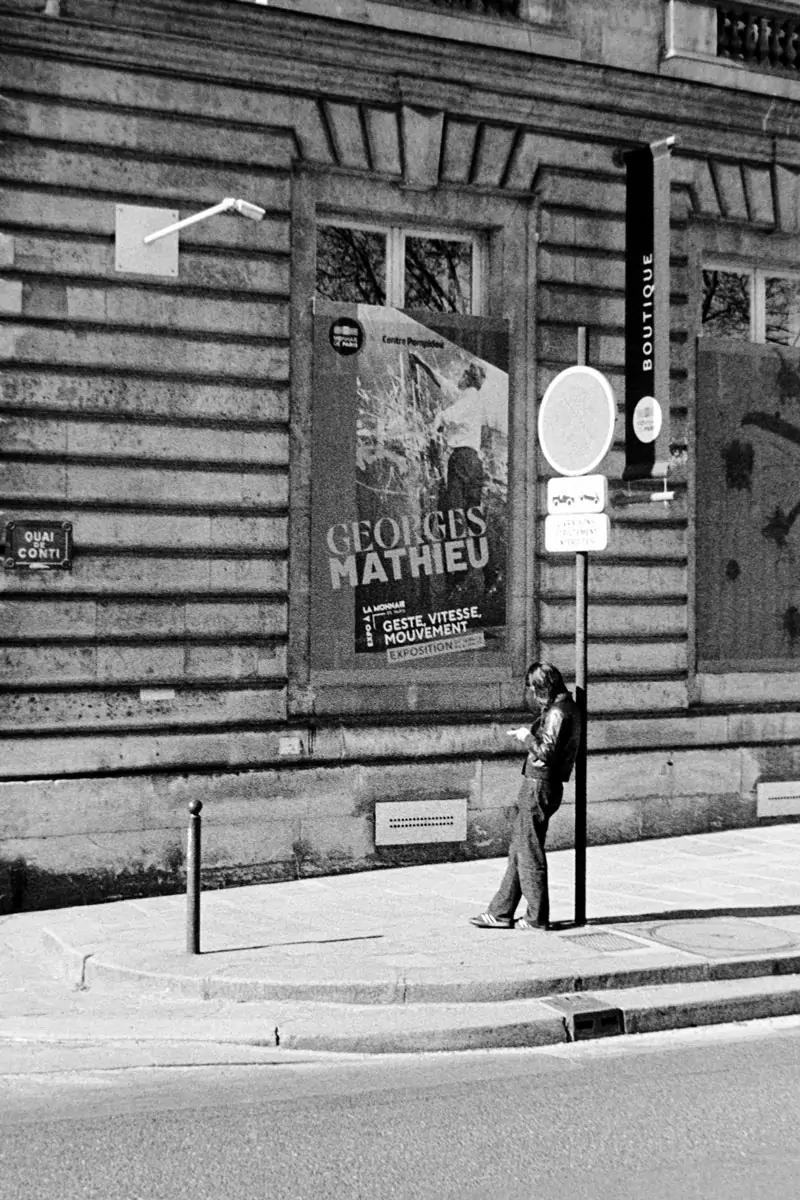 Girl leaning against a street pole